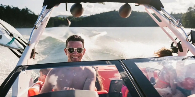 A happy man drives an Axis Wake boat